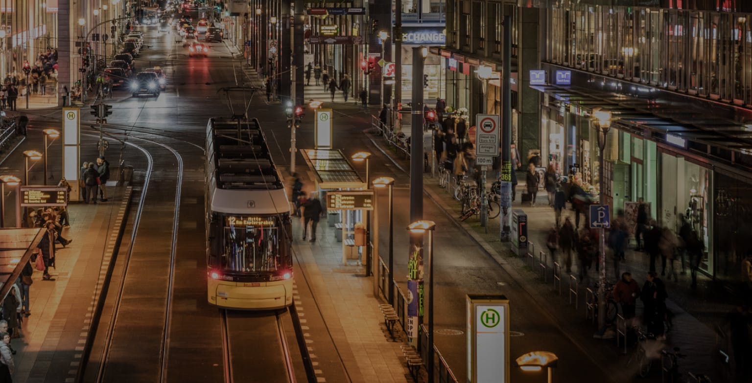 A tram arriving at a tram stop at night within a city